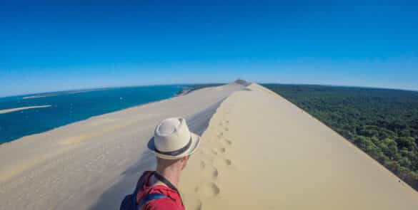 Explorer Arcachon avec ESCAPECAR, Un homme sur la Dune du Pilat en train de se prendre en selfie.